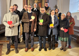 Männer und Frauen des neuen Kirchenvorstandes Altensittenbach stehen zum Gruppenbild am Altar