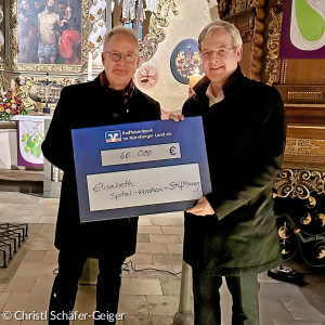 Pfarrer Dr. Gerhardt Knodt übergibt Scheck an Bürgermeister Robert Ilg